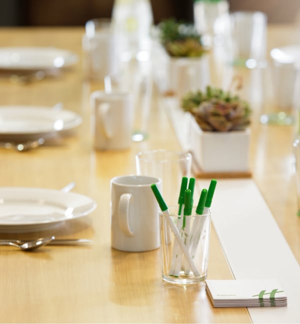 event table with mugs plates and pens